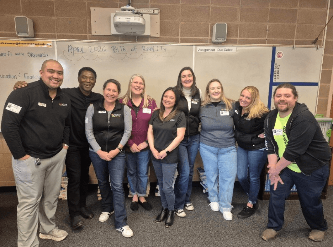 Group of adults standing indoors for a Bite of Reality program photo in front of a classroom whiteboard